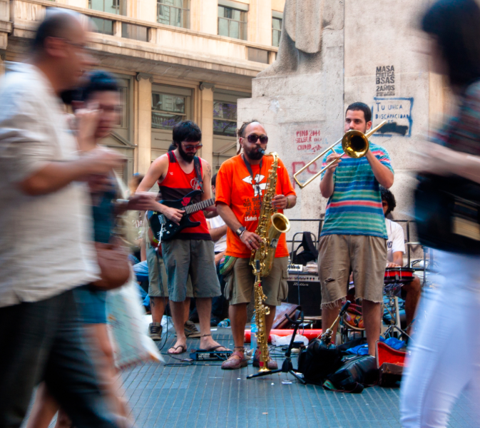 Musicians playing on a busy city street.