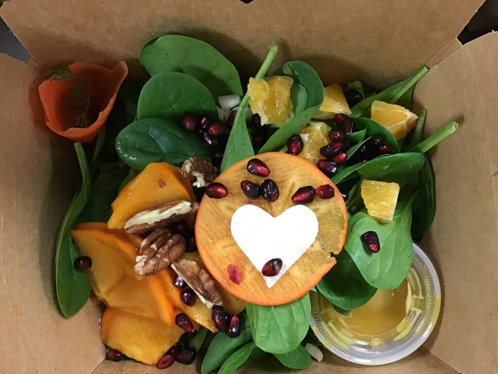 salad in a take out box with heart shaped produce cutout