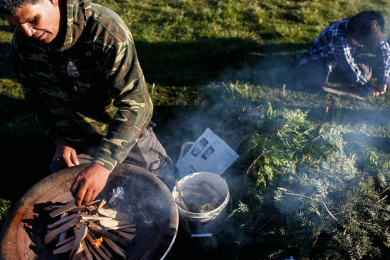 A Wiyot man tends a fire in preparation of the remembrance ceremony.
