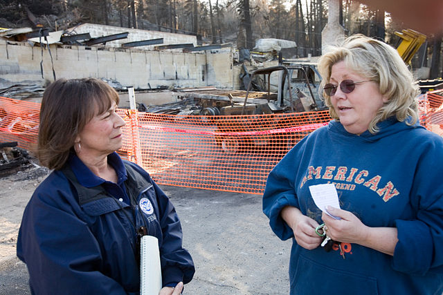 Community relations worker speaks with resident in California following a wildfire Credit: WikiCommons 