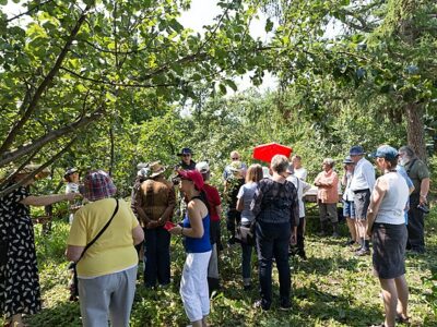 members of a community orchard gather for a viewing and small tour meeting