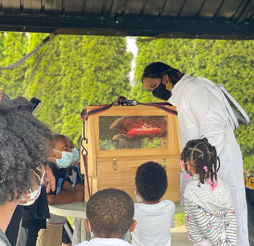 Nicole Lindsey, from the Detroit Hives, shows honeybees up close to children as she teaches them about their lifecycle Credit: Timothy Paule
