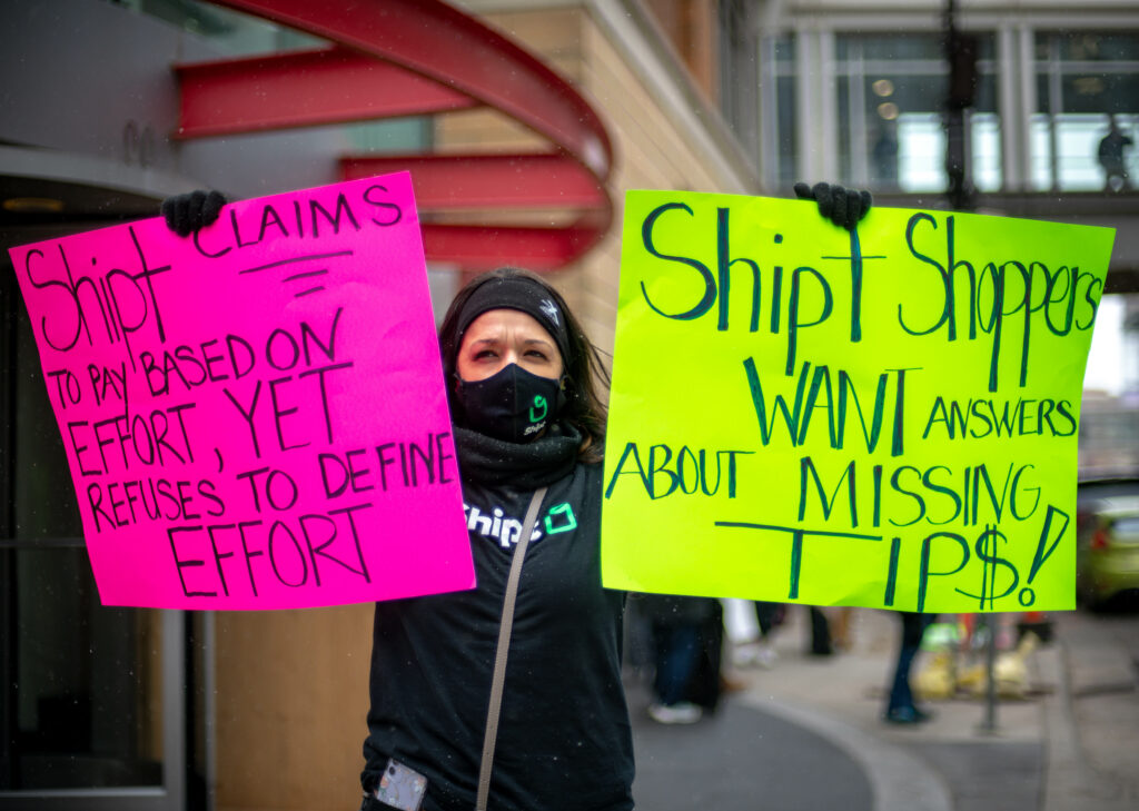 The Solidarity Fund provides support to employees organizing for fair workplace practices. Here, a Shipt shopper is seen holding signs at a demonstration demanding the company repay workers' stolen wages. Credit: The Solidarity Fund