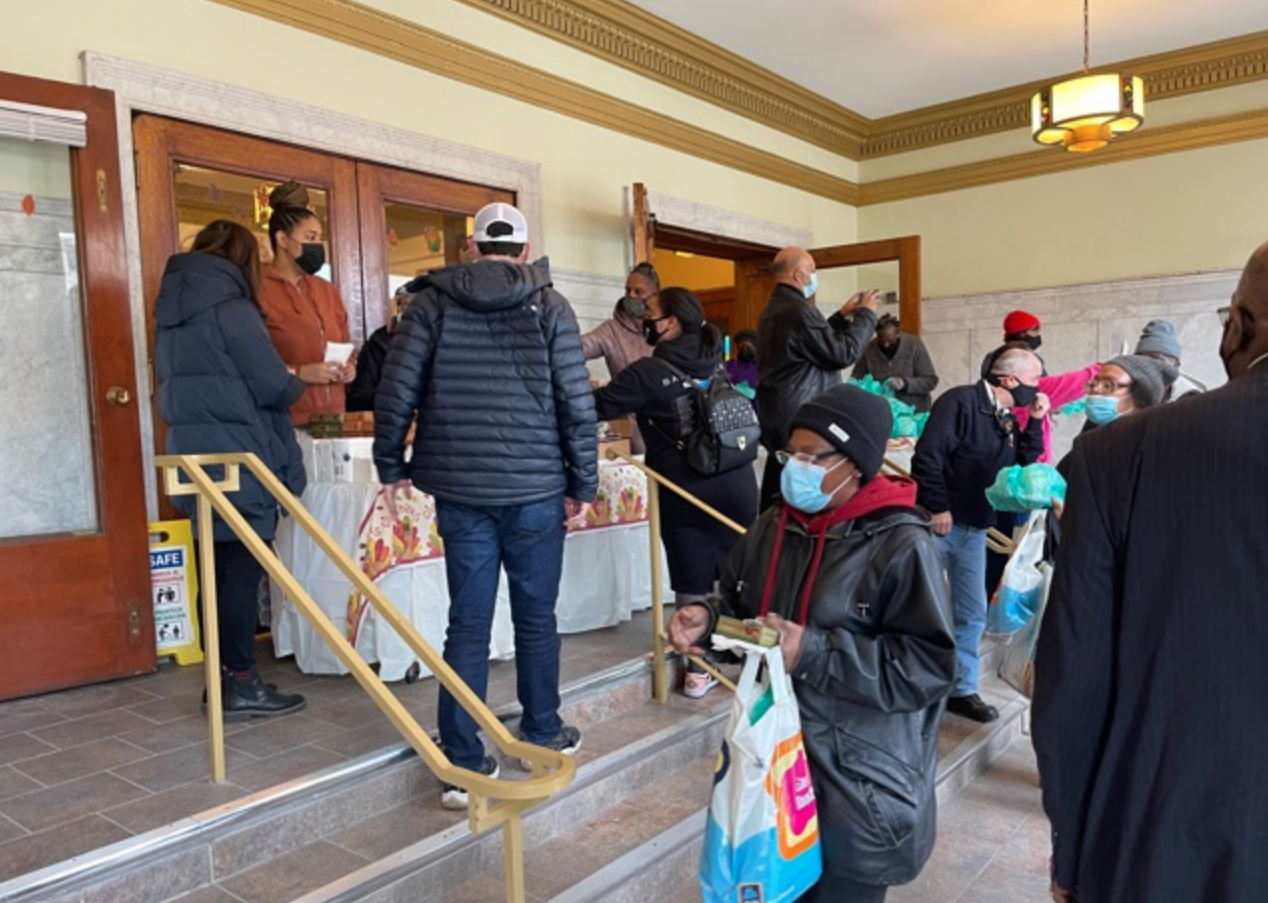 mental health, Community members gather outside the Center for a Thanksgiving food drive. Credit: The Encompassing Center