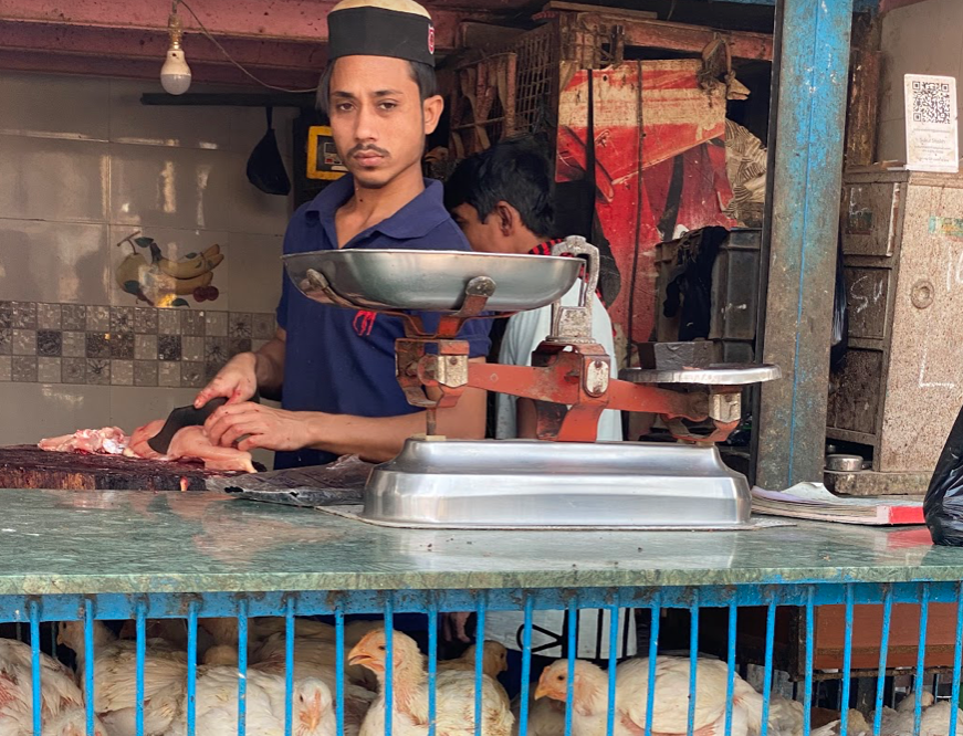 A butcher prepares fresh cuts of poultry. Credit: Jeffrey Andreoni; slums 