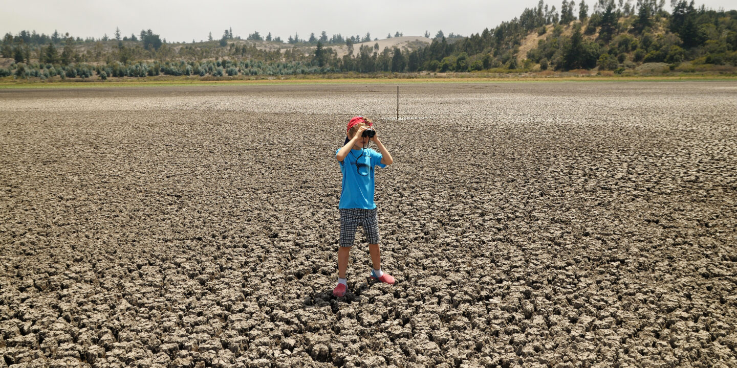 Chilean child stands in the middle of what used to be a lake. El Yali National Reserve, Valparaíso Region, Chile. Credit: Alamy Matter of Trust Chile