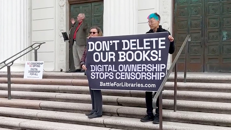 Internet Archive supporters hold up sign reading: "Don't Delete Our Books!"